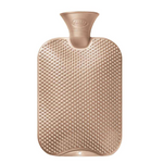 Gold hot water bottle with textured surface on a white background