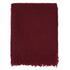 Maroon blanket with fringes on a light gray background