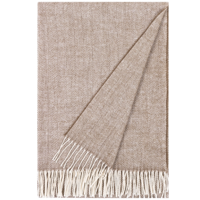 Beige woven blanket with white fringe on a plain background